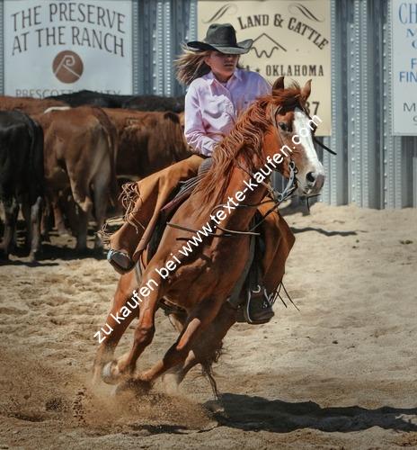 Frau im Westernlook am reiten auf den Pferd